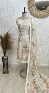 Floral dress on a mannequin with a matching dupatta in front of a mirror.