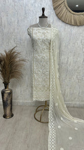 “Off-white georgette unstitched suit set with intricate white embroidery and pearl work, paired with sheer embroidered dupatta on mannequin.”