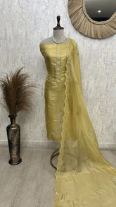 Yellow saree with lace details on a mannequin against a textured wall.