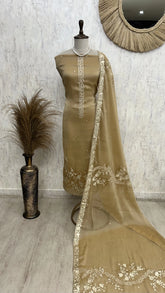 Brown traditional outfit with embroidered dupatta on a mannequin against a light gray wall.