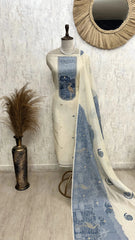 Mannequin wearing a blue and white patterned dress with a decorative mirror and vase in the background.