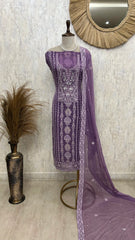 Purple embroidered dress on a mannequin with a decorative mirror and vase in the background.
