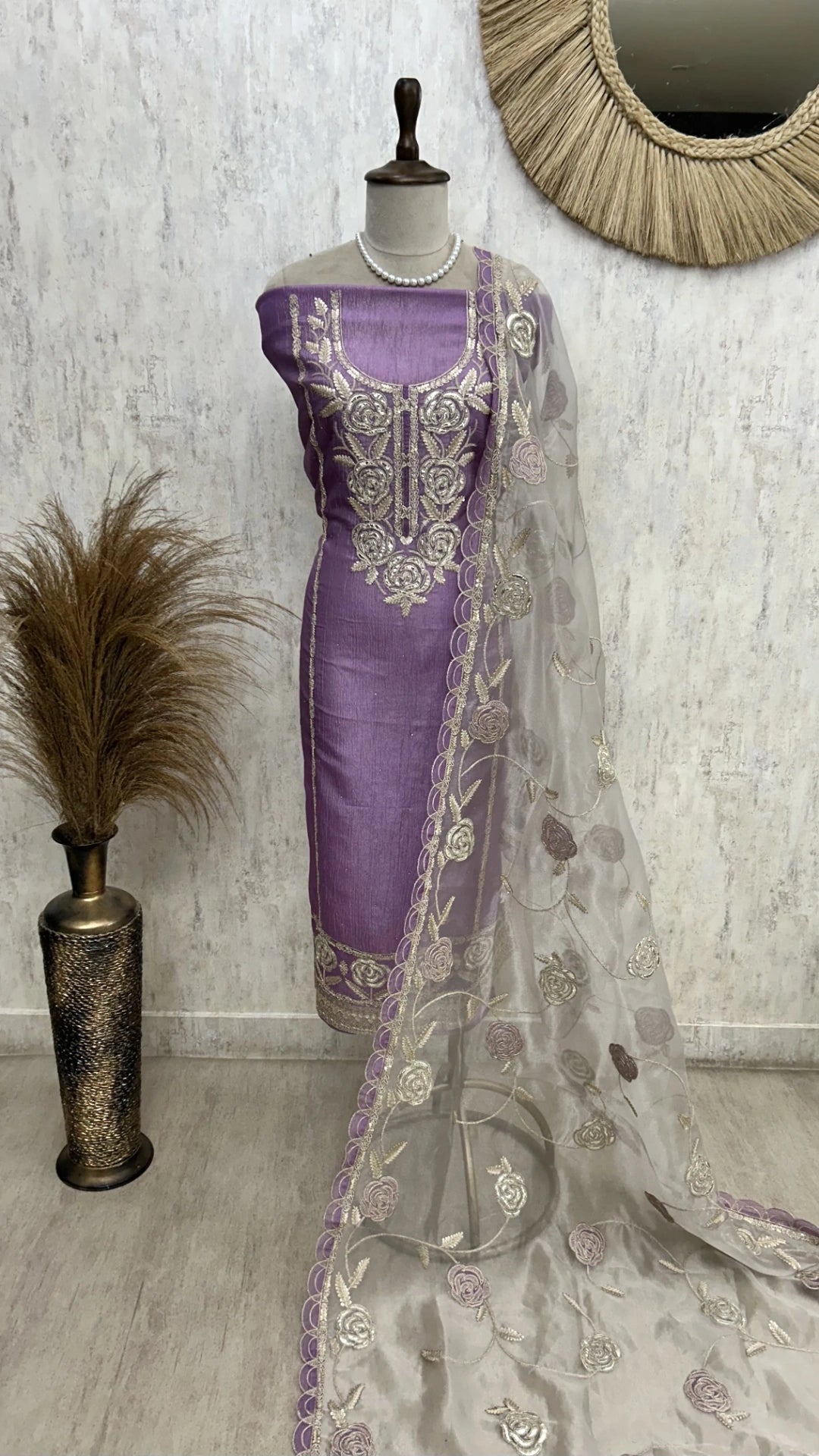 Purple saree with silver embroidery on a mannequin against a white wall.