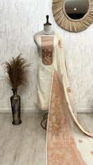 Mannequin with a long, patterned fabric draped over it against a neutral wall.